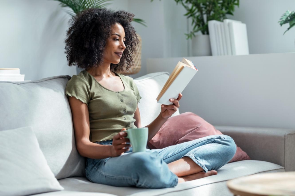 Woman reading a book in her home after air conditioning services have been provided.