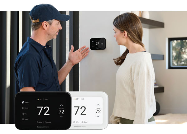HVAC Tech showing woman how to use smart thermostats